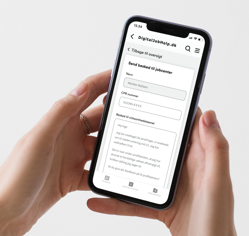 Person kigger på sin mobil, i appen Digital JobHelp, hvor den jobsøgende kan skrive en besked til sin rådgiver på sit tilknyttede jobcenter